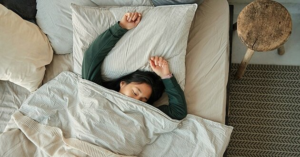 Woman sleeping deeply in bed, illustrating the concept of catching up on sleep