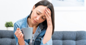 Tired woman holding a coffee mug, showing signs of sleep deprivation despite 8 hours of sleep.